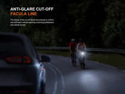 Two cyclists on a dark road with a car, highlighting the anti-glare cut-off feature of the Fenix BC22R Bike Light facula line. 