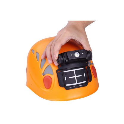 Black helmet mount fixed to a climbing helmet with a hand attaching a headlamp. 
