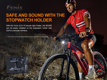 Biker on a bicycle at night with text about a stopwatch holder and Fenix brand.