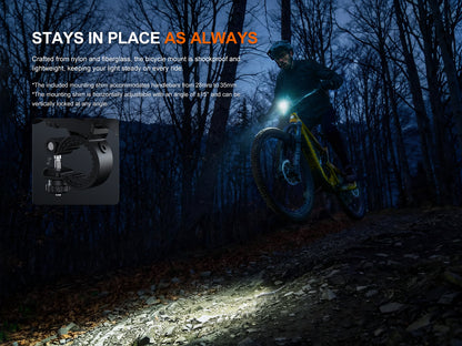 Biker riding a mountain bike at night with a Fenix BC45R Bike Light on, surrounded by trees.