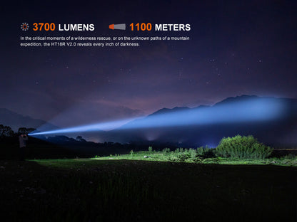 Light beam from a Fenix HT18R V2.0 Flashlight illuminating a mountainous landscape with text about lumens and range.