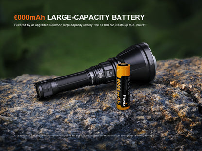Fenix HT18R V2.0 Flashlight and battery on a rock with text about large-capacity battery