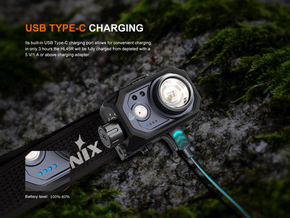 Fenix HL45R Headlamp charging with an USB C cable on a mossy rock. 