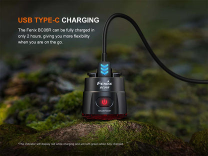 Fenix BC06R Tail Light fast charging with USB C type cable on a rocky surface and blurry background. 